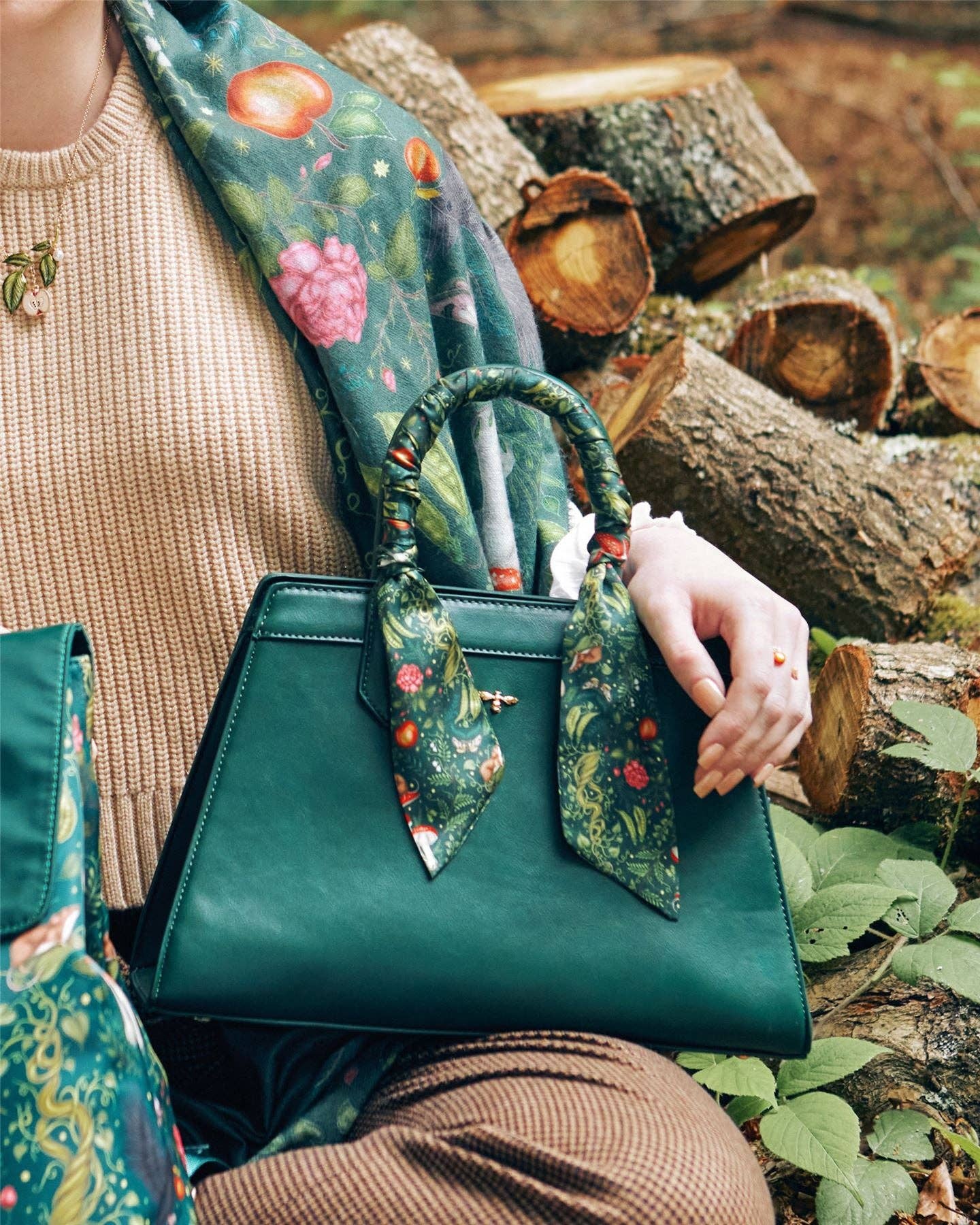A handbag with a green scarf with a woodland print